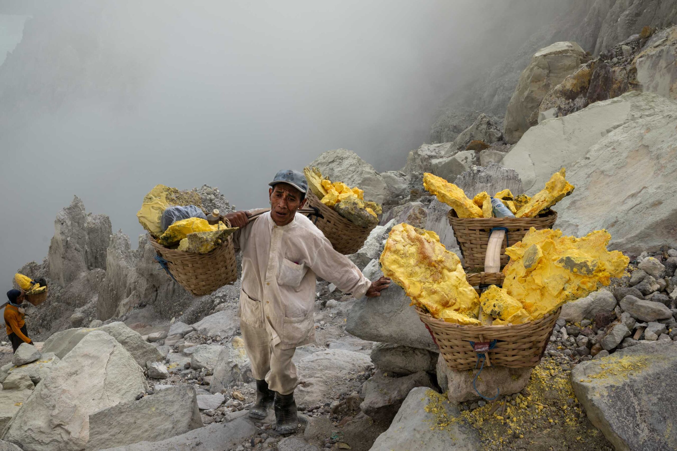 Sulphur miner carrying two loaded baskets, Ijen, Indonesia