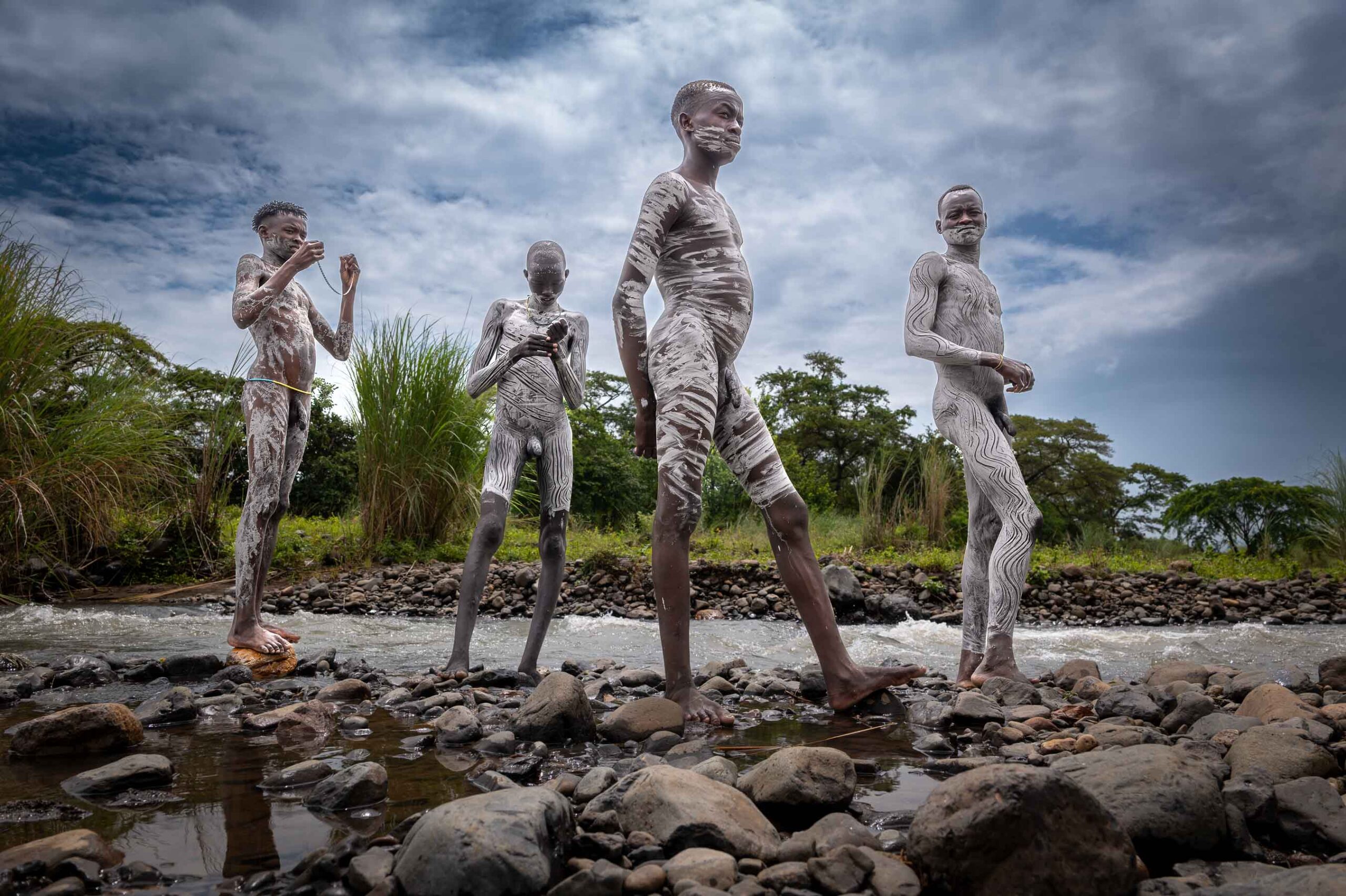 Group of boys with painted bodies by the river, Omo Valley, Ethiopia