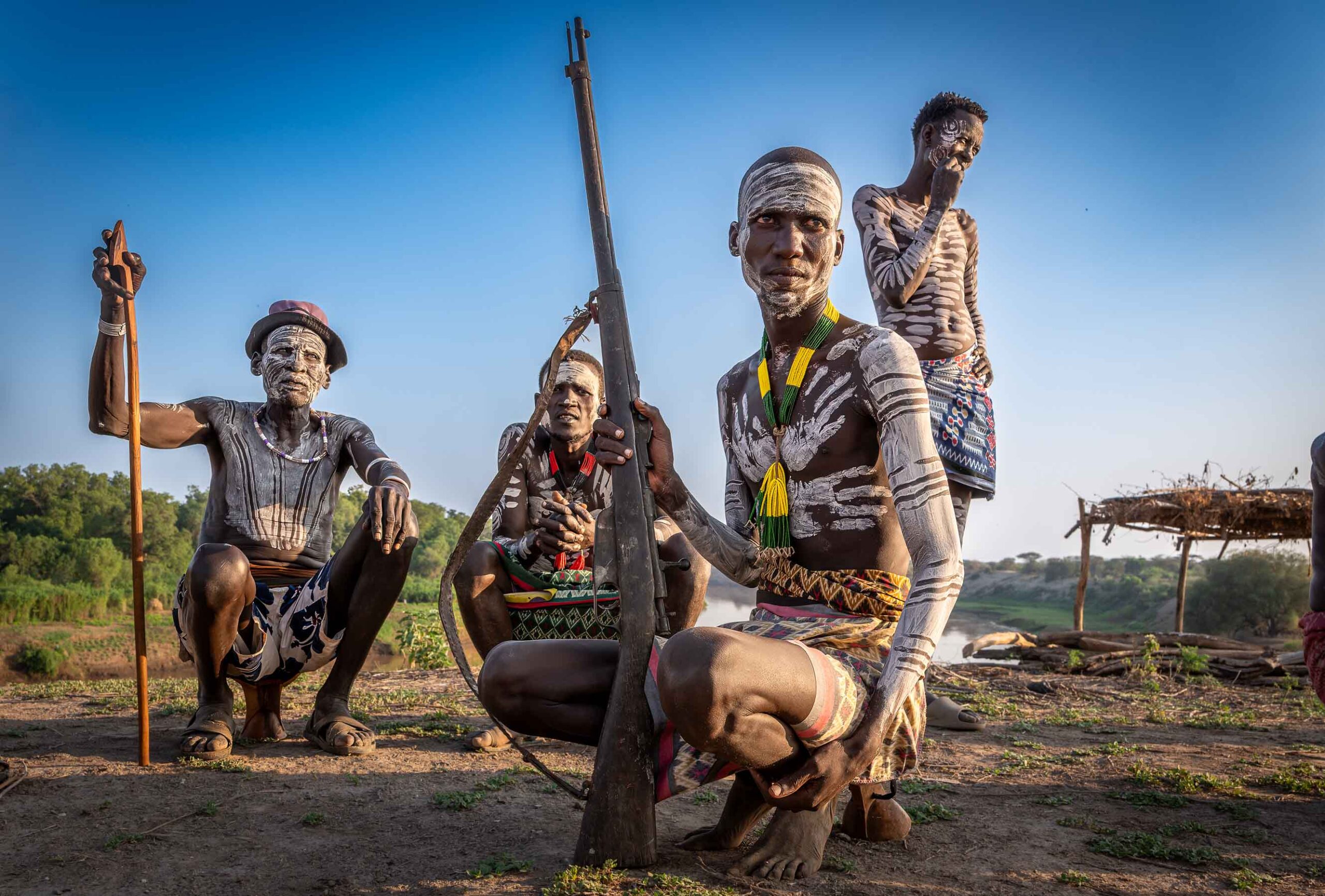 Men with rifles and body paint, Omo Valley, Ethiopia