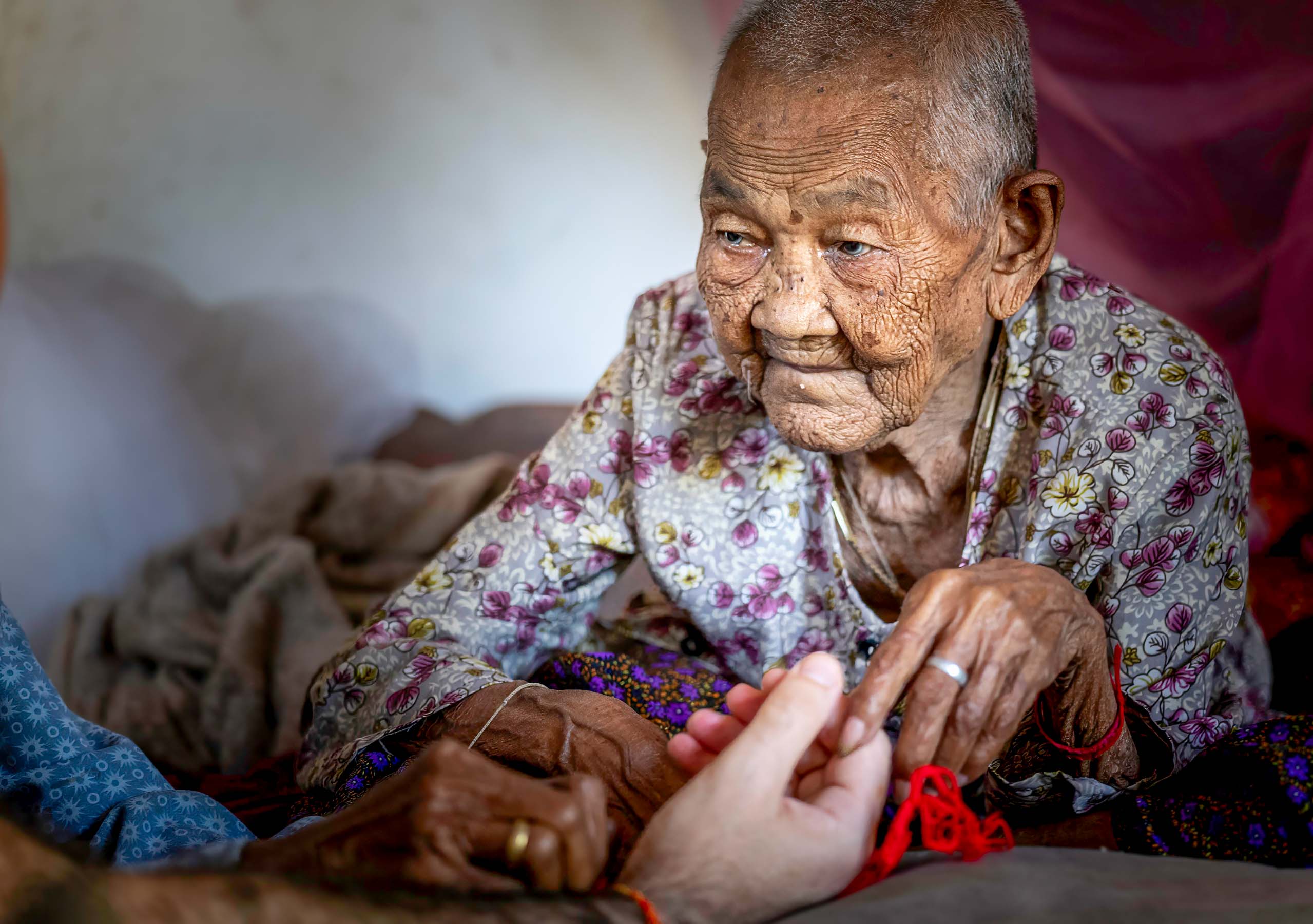 Elderly nun giving the blessing, Cambodia