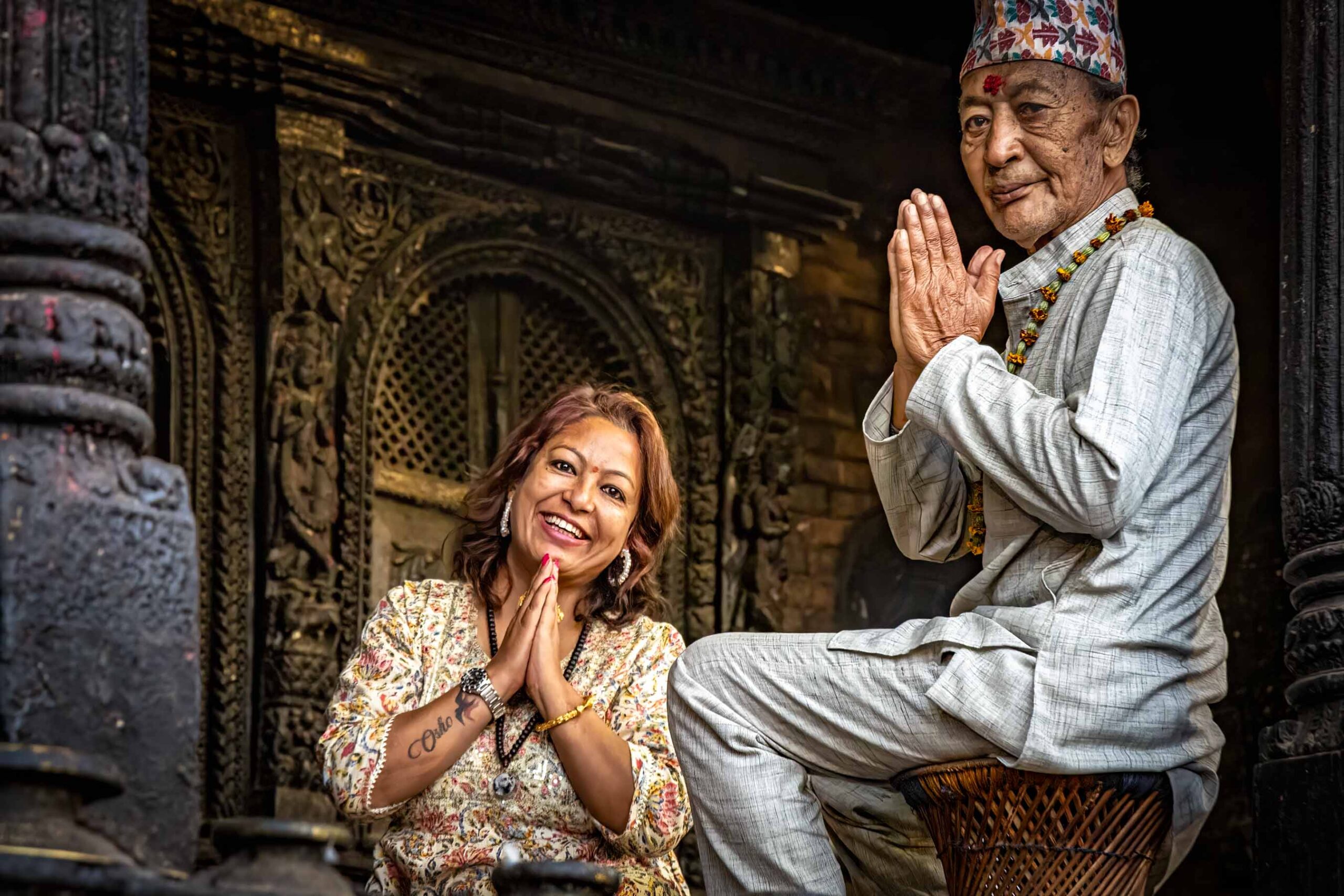 Two people greeting each other outside a temple, Nepal