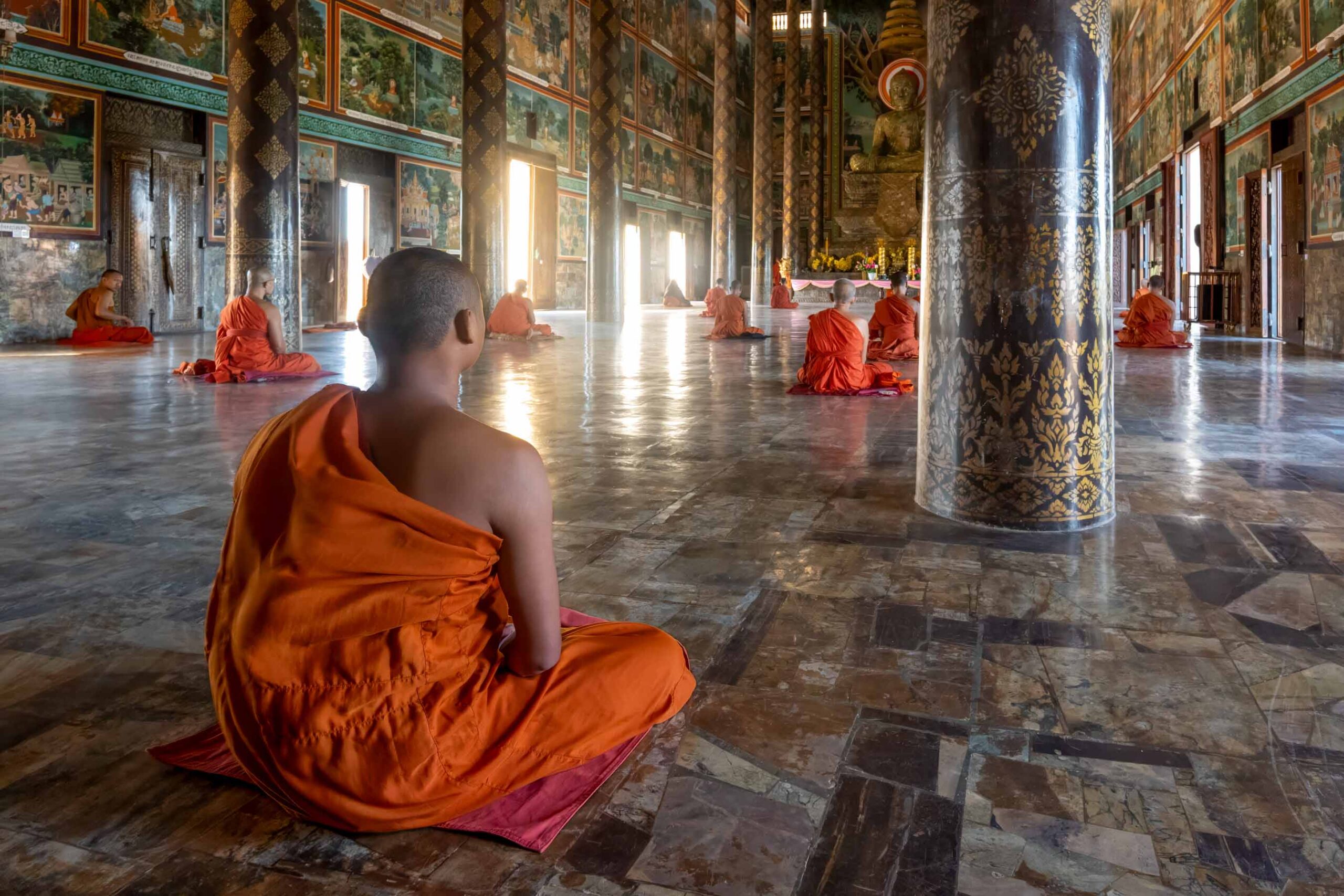 Monks meditating inside a temple hall, Cambodia